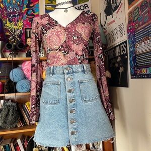 Denim mini skirt with frayed hem enclosed with buttons